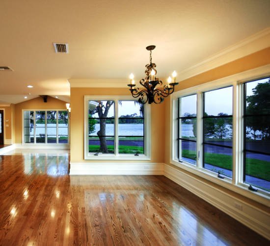 Bright living room with hardwood floors, chandelier and lakeside windows